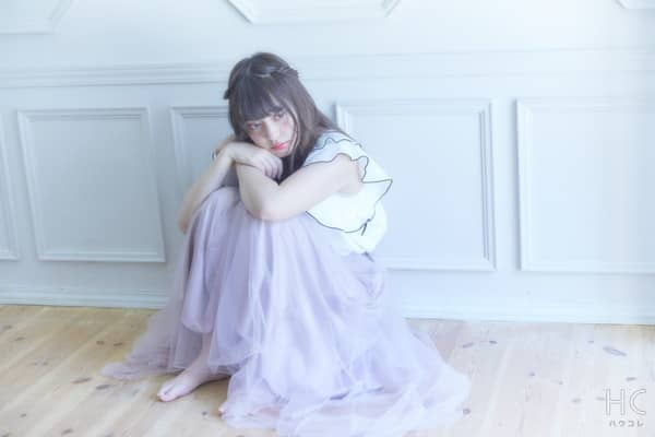 床で膝を抱き思い悩む女性
