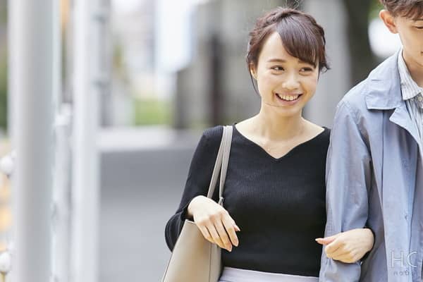 彼に腕を回し嬉しそうにデートする女性