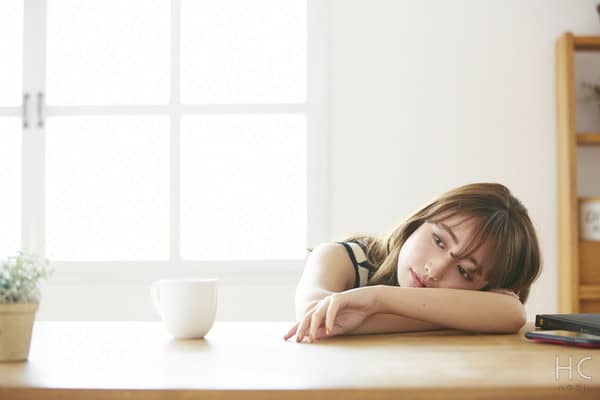 机に寝そべる気だるそうな女性