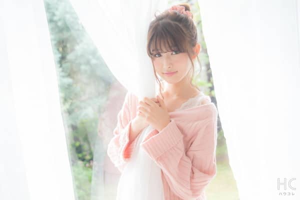 カーテンを抱く笑顔の女性