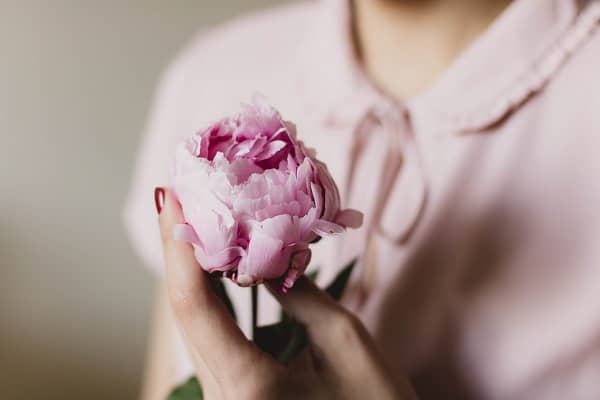 花を胸の前で持つ女性
