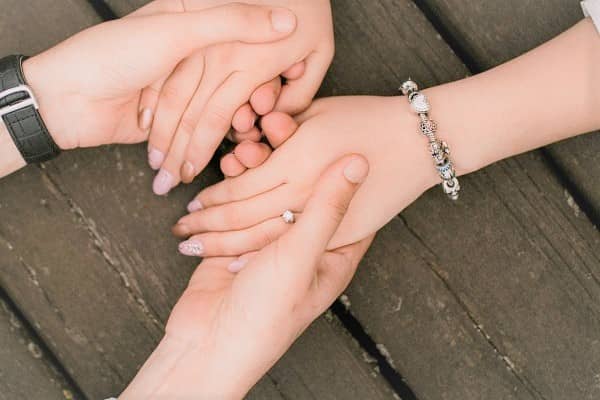手をつなぐカップルの手元