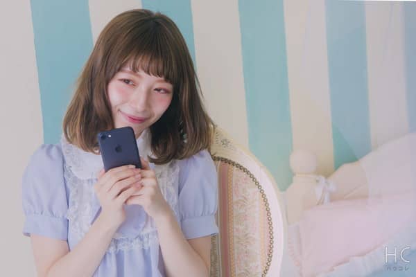 スマホを手にして微笑む女性