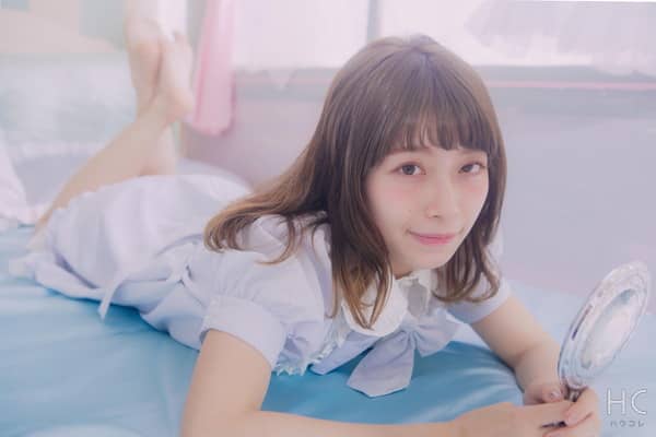 寝そべって鏡を持つ女性