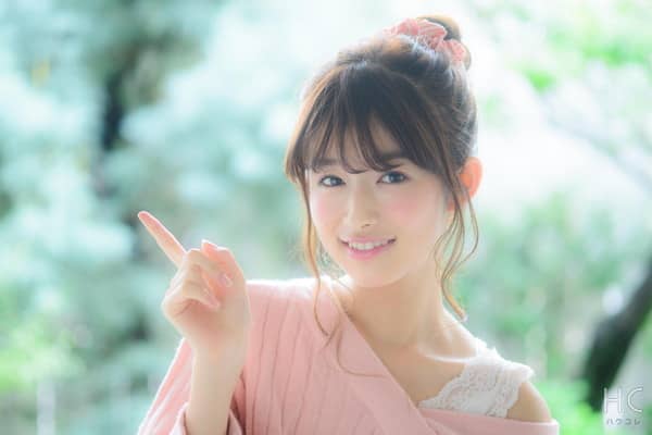 指を掲げて笑顔の女性