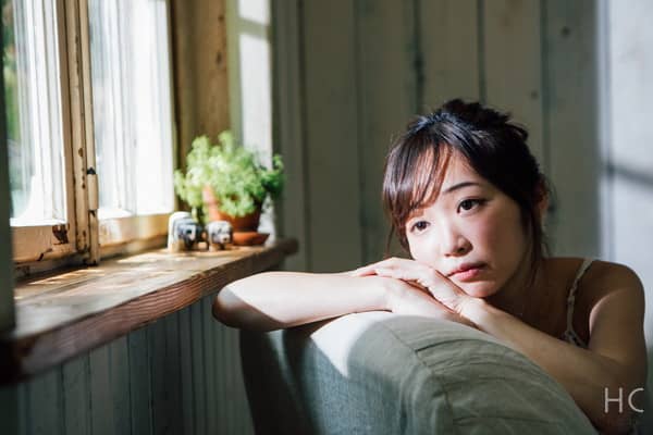 椅子にもたれて顔を出す女性